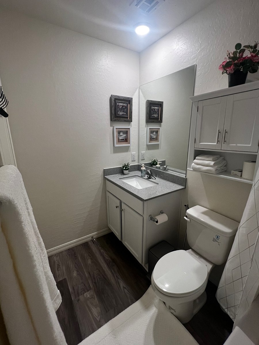 Full Bathroom 1 - Toilet Bowl with Bidet/Water Sprayer, Cabinets with towels, and sink.