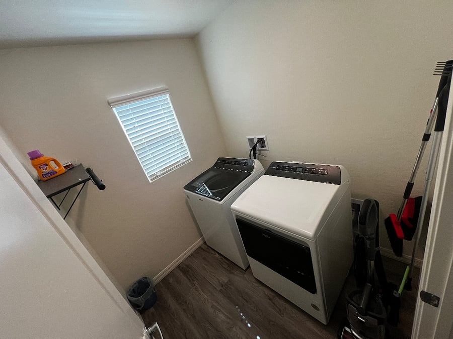 Dedicated laundry room with brand new Whirlpool washer and dryer, cleaning broom and pan, swiffer, and new Shark vacuum clean.