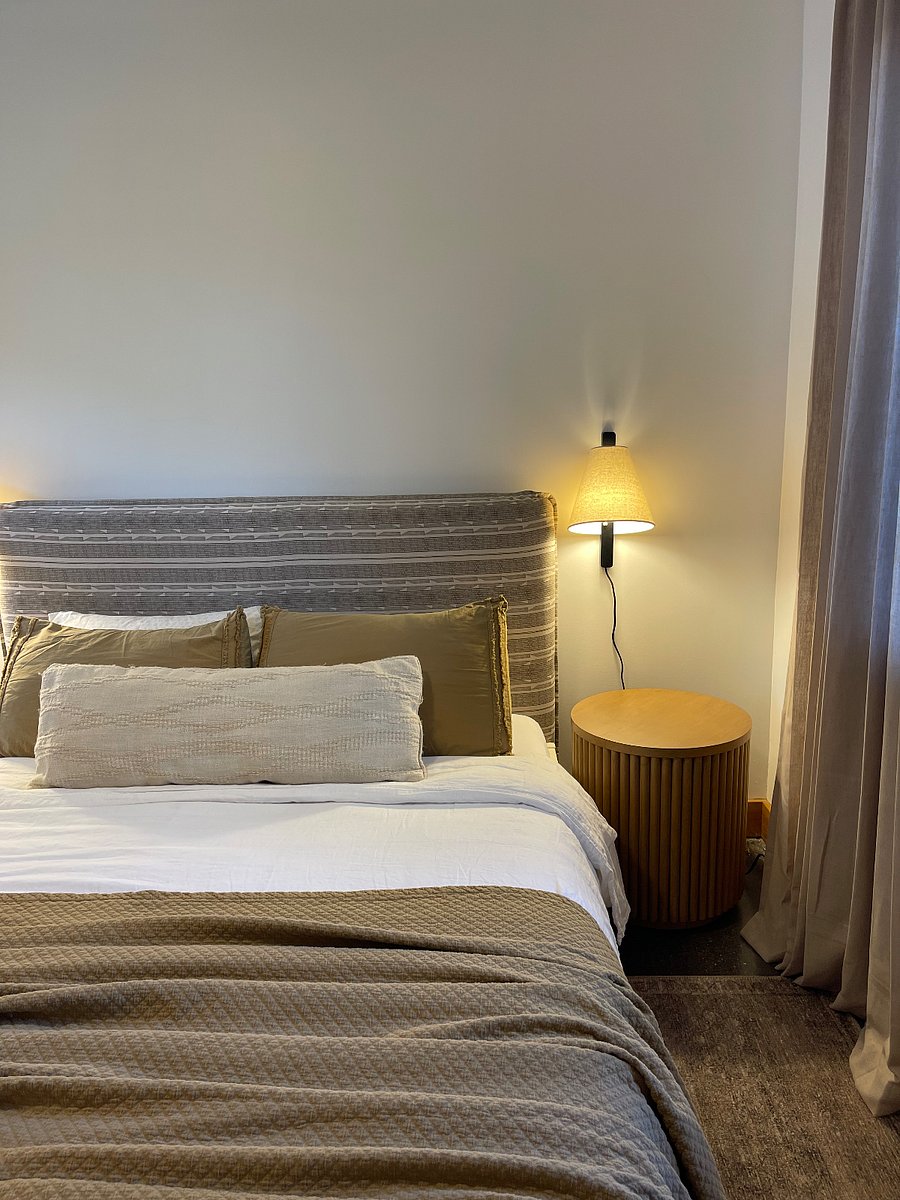 Cozy headboard and bedding, plug in reading sconces at bedside. 