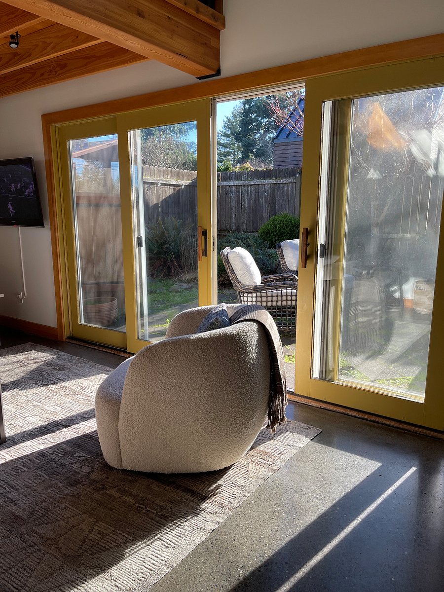 Living room, with view to enclosed back patio accessed through sliding doors. 