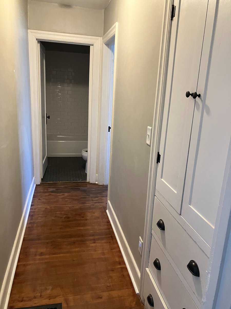 Hallway to the rear of the unit with original built-ins for linens and storage. Towels and linens are provided.