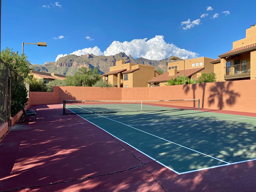 Play a friendly match of tennis on the community tennis court, set against a backdrop of an unforgettable mountain view.