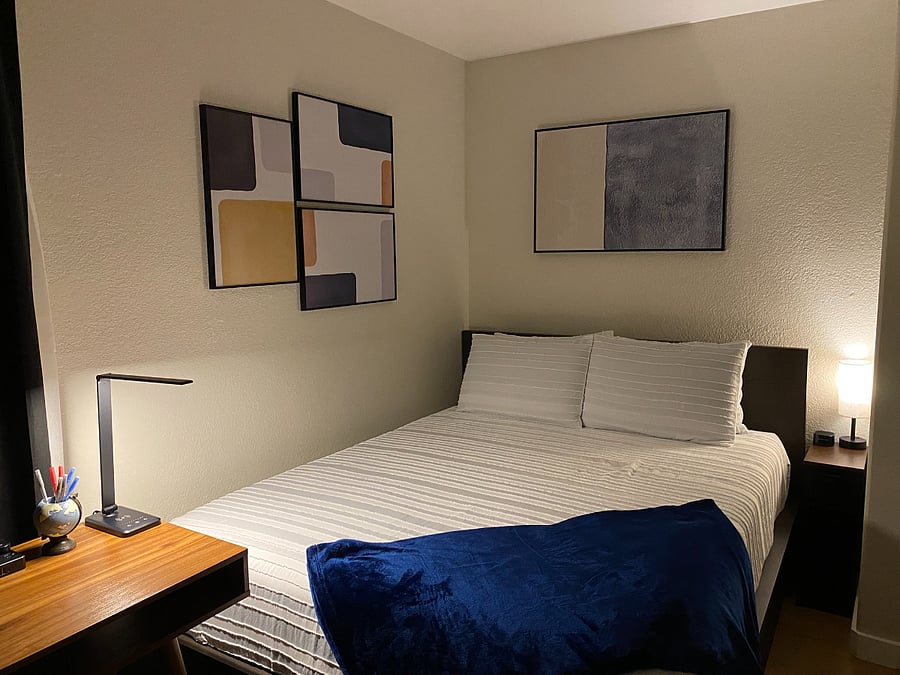 Layered lighting casts a warm glow throughout the room, creating a peaceful setting for reading, unwinding, and easing into a restful night's sleep.