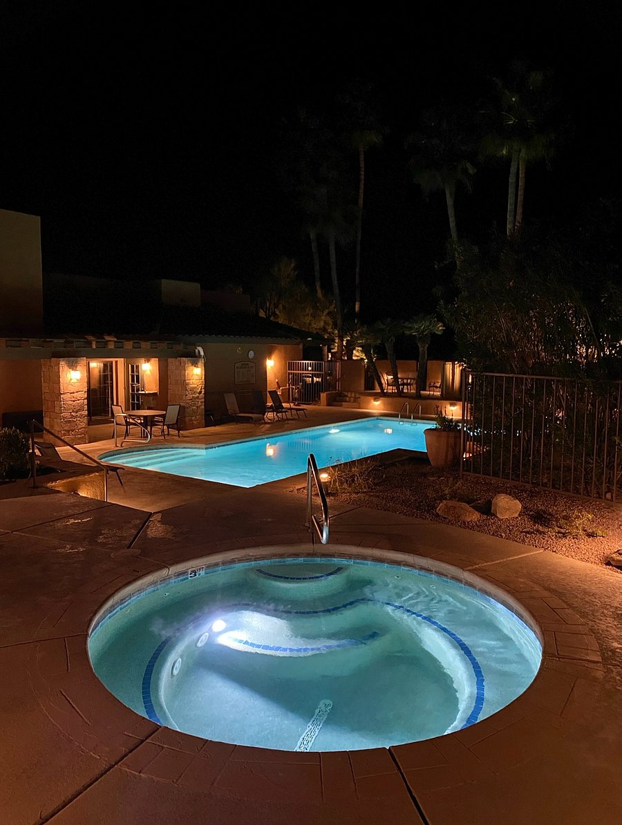 At night, the pool and hot tub transform into a glowing desert oasis that is perfect for swimming, soaking, or stargazing under the warm evening sky.
