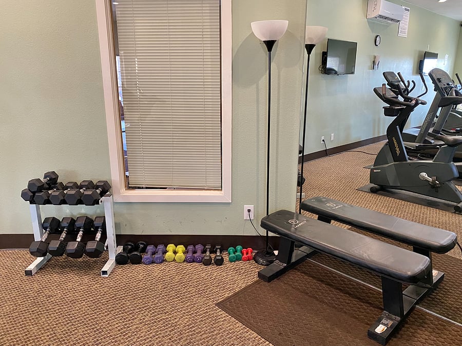 Maintain your strength training goals while on the road with access to a gym containing a dedicated workout bench and an array of free weights.