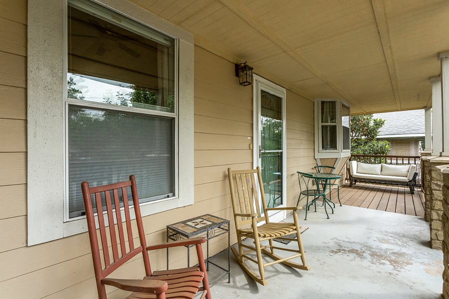 The large front porch is perfect for relaxing, overlooking the gardens.