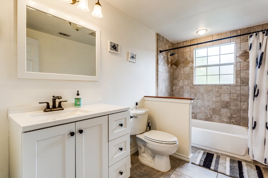 Hallway bathroom is large and has a bathtub.