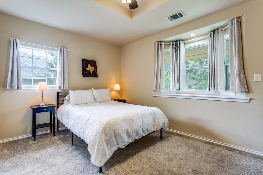 Second bedroom with queen bed and double-door closet with built-in shelving.