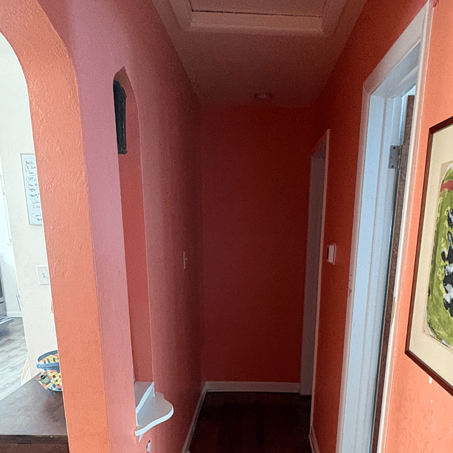 brightly painted hallway - primary bedroom is at the end, then bathroom, then kids room immediately to the right, and the large spacious open floor plan to the left