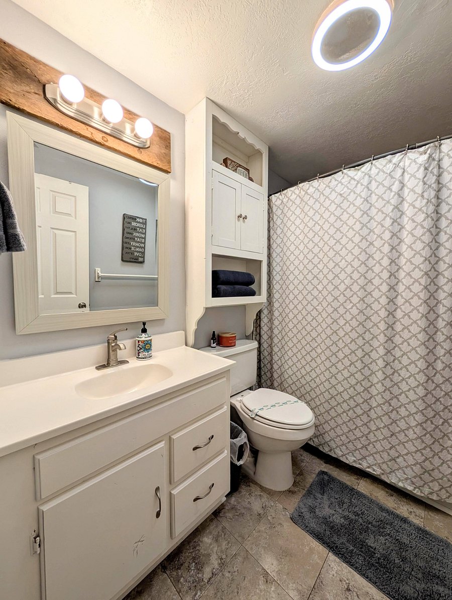 Upstairs full bathroom with handheld hose shower head.
