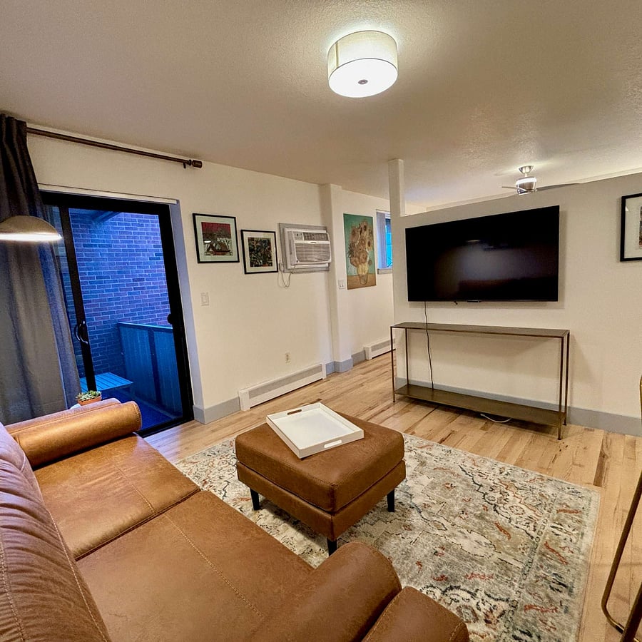 Living area, entrance to patio, and passage to bedroom