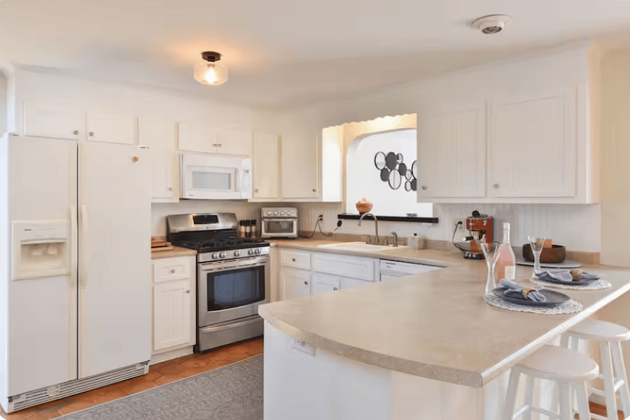 The kitchen is beautifully appointed with modern amenities and a clean, inviting design. Featuring a gas range, dishwasher, and ample counter space, its both functional and stylishperfect for everything from everyday meals to relaxed entertaining. Thoughtfully laid out with a breakfast bar and adjacent dining area, it creates an easy, comfortable flow for living.