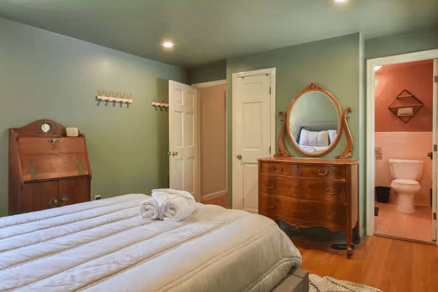 The primary bedroom features a queen bed and an en-suite full bathroom, offering a private and comfortable space for extended stays. Bright and inviting, its designed for both relaxation and everyday living.