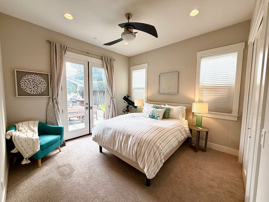 Downstairs suite with queen size bed, entrance to patio, and ensuite bathroom