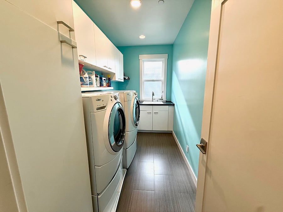 Upstairs laundry room with ironing board and steamer