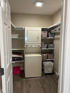 Walk in closet with stackable washer dryer, shelves, cleaning supplies, iron, midsize iron board, linen supplies, pillows, blankets, tv tray, and small drawer,