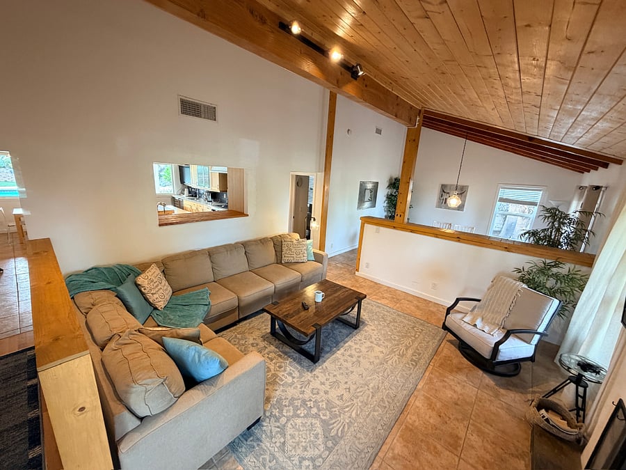 Bright and inviting living room with vaulted ceilings, natural light, and a cozy space to relax.