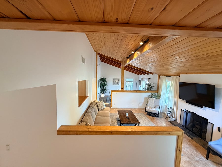Bright and inviting living room with vaulted ceilings, natural light, and a cozy space to relax.