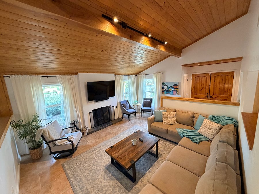 Bright and inviting living room with vaulted ceilings, natural light, and a cozy space to relax.
