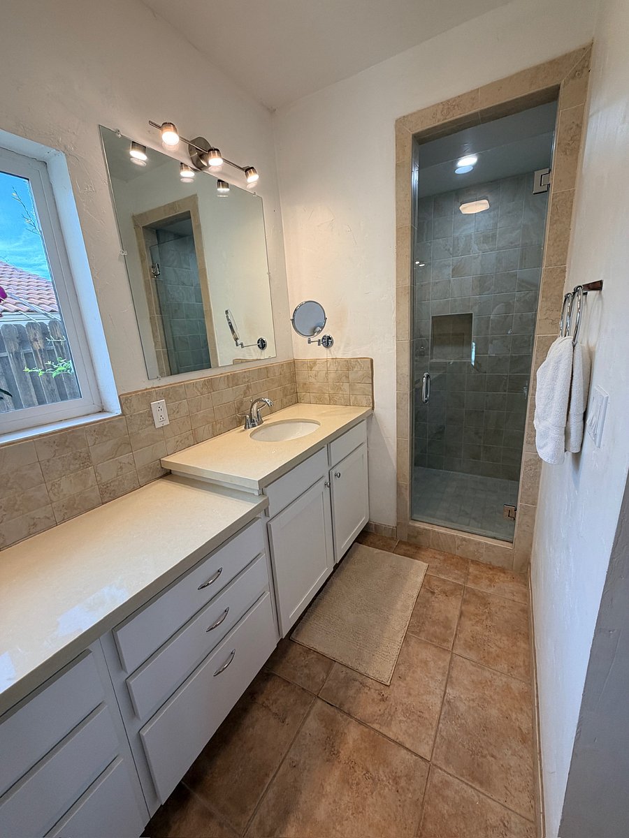 Primary in-suite full bathroom featuring double sinks and a spa-like shower.