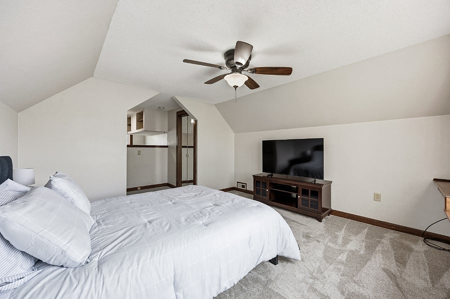 Spacious bedroom with a TV and ample closet space