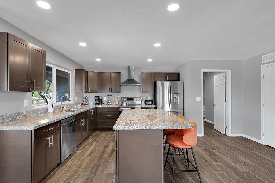 Dine in style at this elegant, minimalist table set beneath warm lighting. The open layout connects seamlessly to the living space, creating a relaxed and social atmosphere.