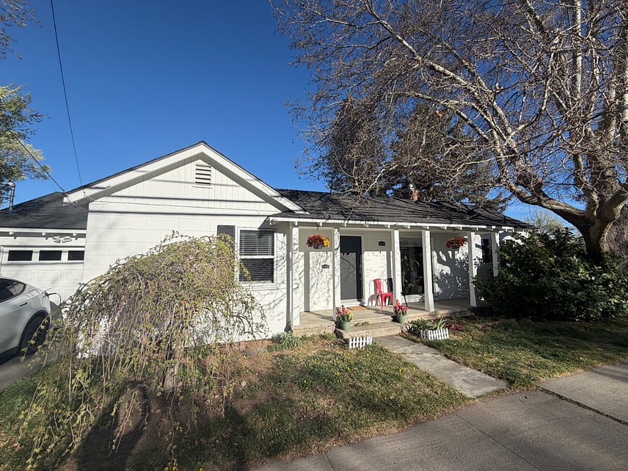Entrance with covered patio, spring/summer perennial flowers, access to the garage and parking. Door has a keypad for entry.