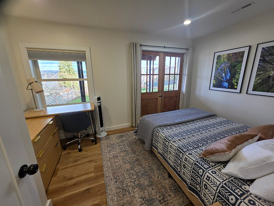 Bedroom has blackout curtains for window and doors. Large closet to the left of picture.