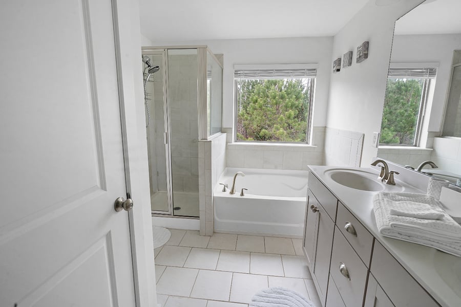 Spacious bathroom with soaking tub, shower, and natural light.