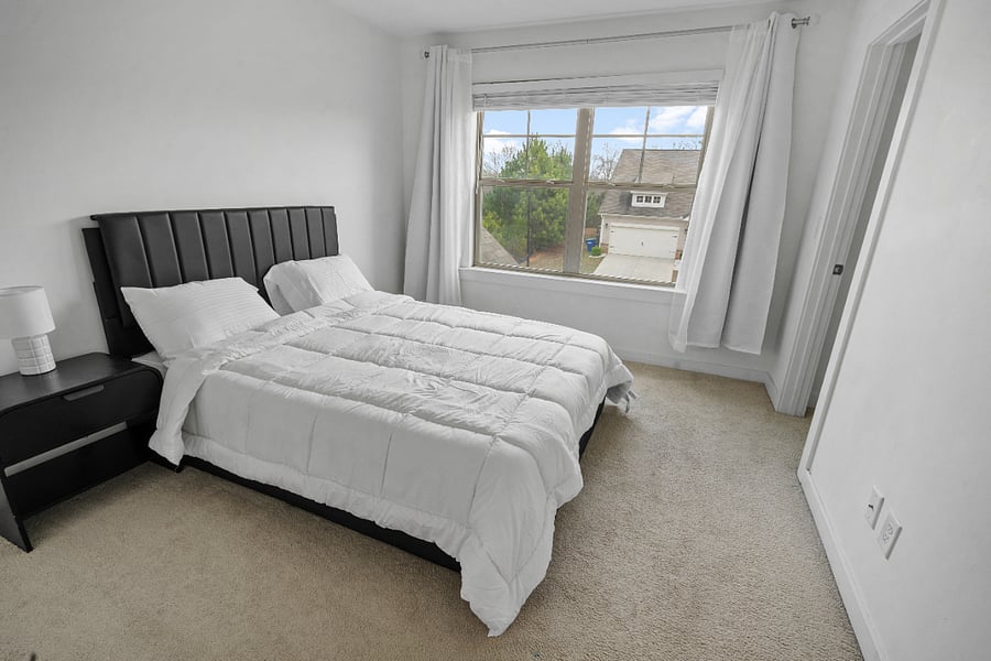 Comfortable bedroom with natural light and cozy setup.