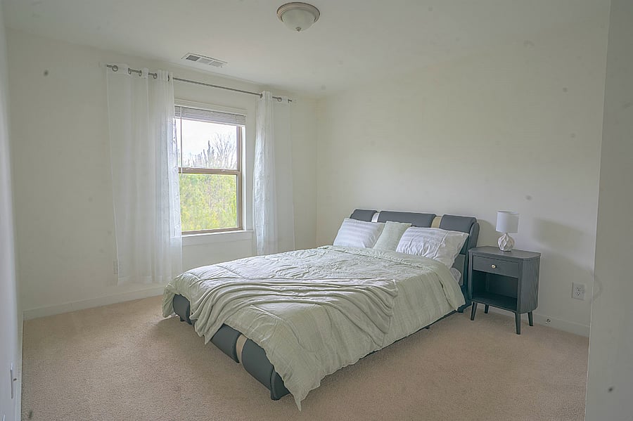Inviting bedroom with plush bedding and warm tones.