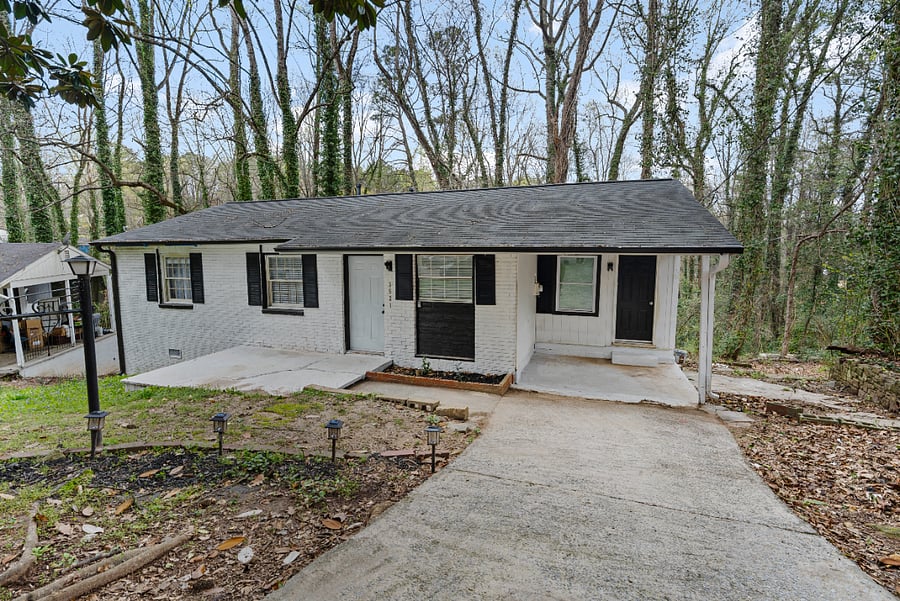 Charming exterior with private driveway and peaceful setting.