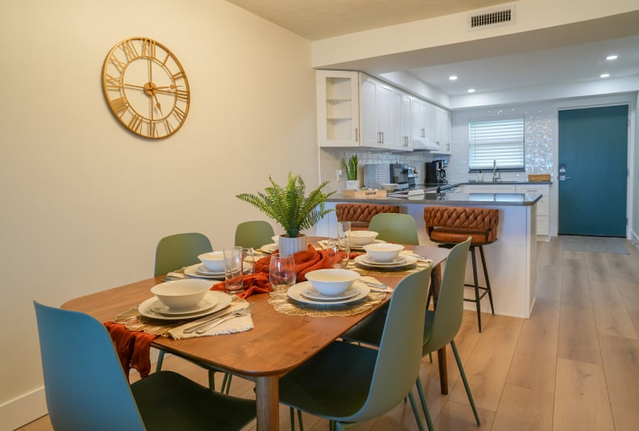 Dining area features 6 chairs and 2 bar stools