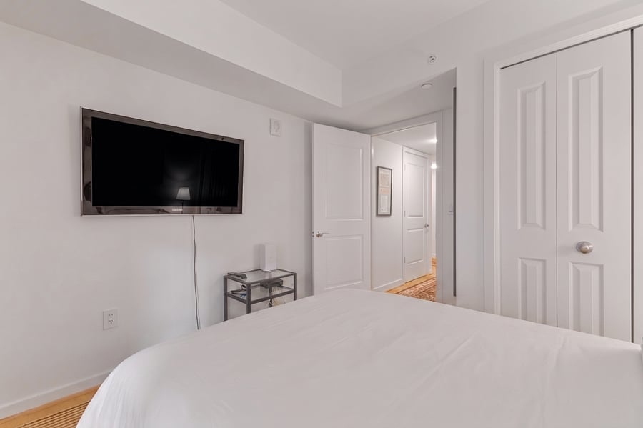 Unwind with your favorite shows from bed with the wall-mounted flat-screen TV in this clean, modern room.
