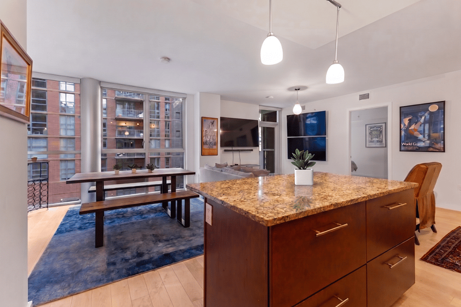The expansive open-plan layout bridges the kitchen and dining areas, creating a perfect flow for entertaining against a backdrop of city views.
