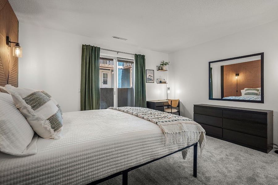 Bedroom with queen bed, dedicated work station, several storage options, natural lighting, blackout curtains