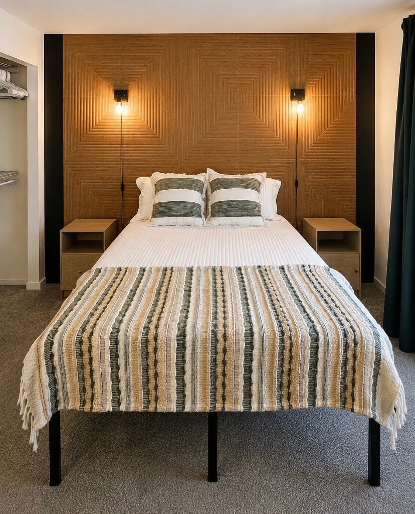 Bedroom with queen bed, dedicated work station, several storage options, natural lighting, blackout curtains