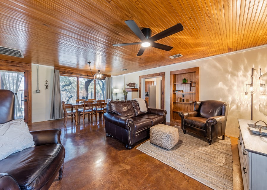 Large picture window looks out to a tree-lined yard.