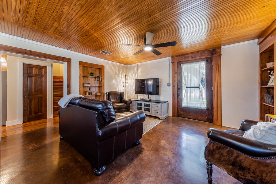 Vintage front door with full glass window. Wood ceilings and ceiling fan.