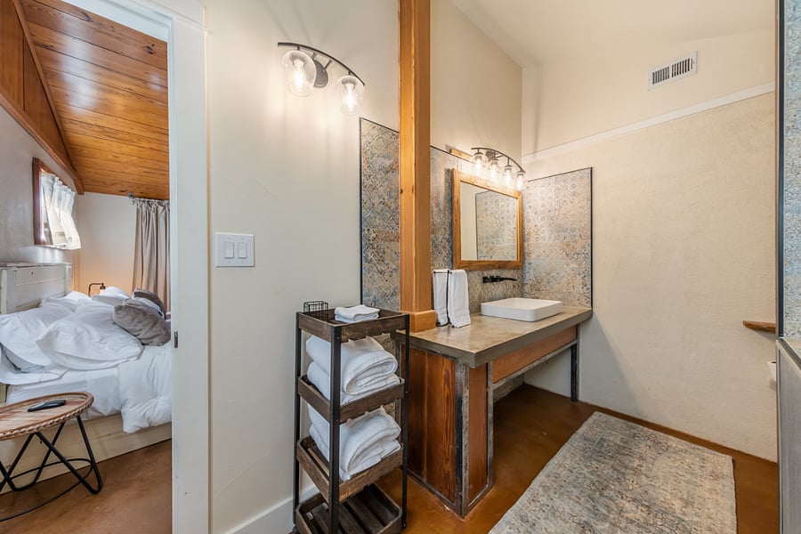 The primary ensuite has a vessel sink and concrete counters.