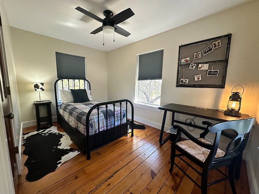 The third bedroom is located on the second floor, has a twin rod iron bed, a walk-in closet, and blackout blinds.