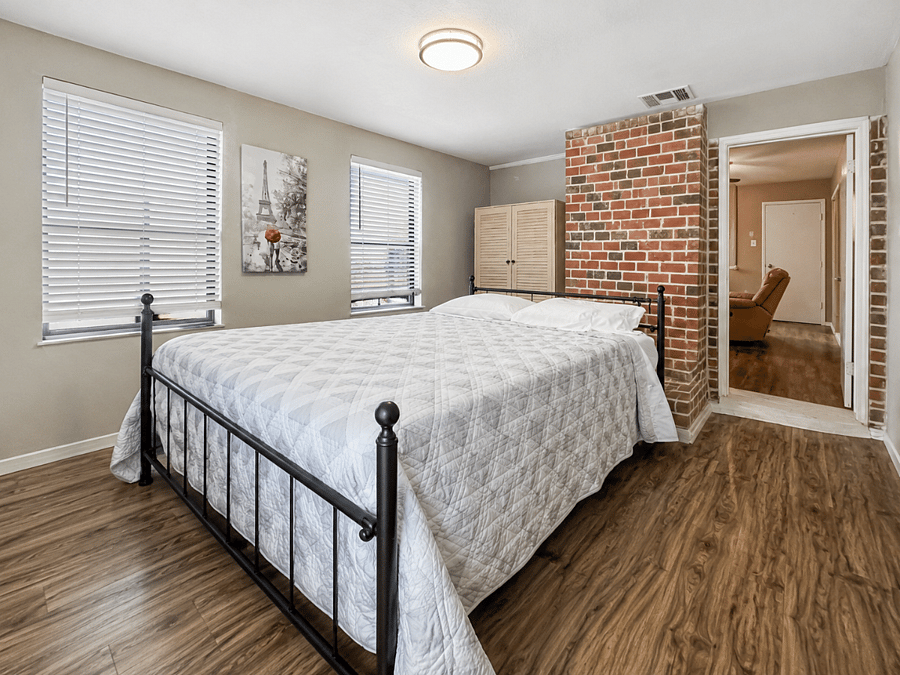 Charming bedroom with a stylish exposed-brick accent wall - a warm, welcoming retreat for your extended stay.