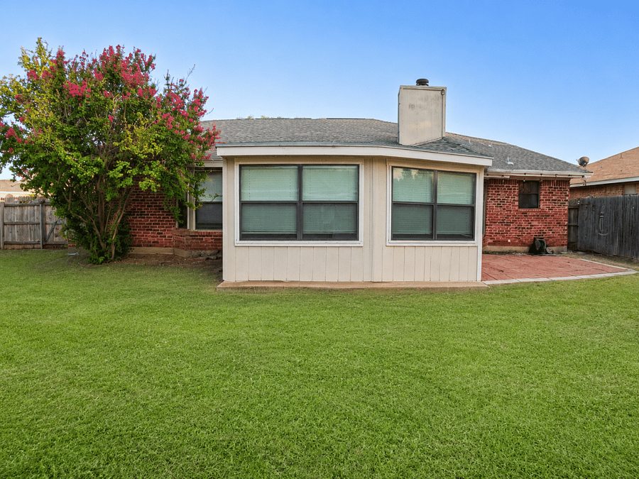 Private fenced backyard with a spacious lawn - a peaceful outdoor space to decompress on your days off.