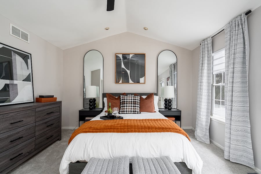 Spacious, upscale master suite with vaulted ceilings, layered textures, and refined finishes designed for comfort and style. Thoughtfully styled with plush bedding and warm accents to create a relaxing, high-end retreat.