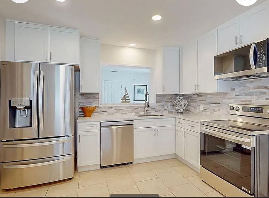 Bright, fully equipped shared kitchen featuring LG French door refrigerator, dishwasher, and quartz countertops
