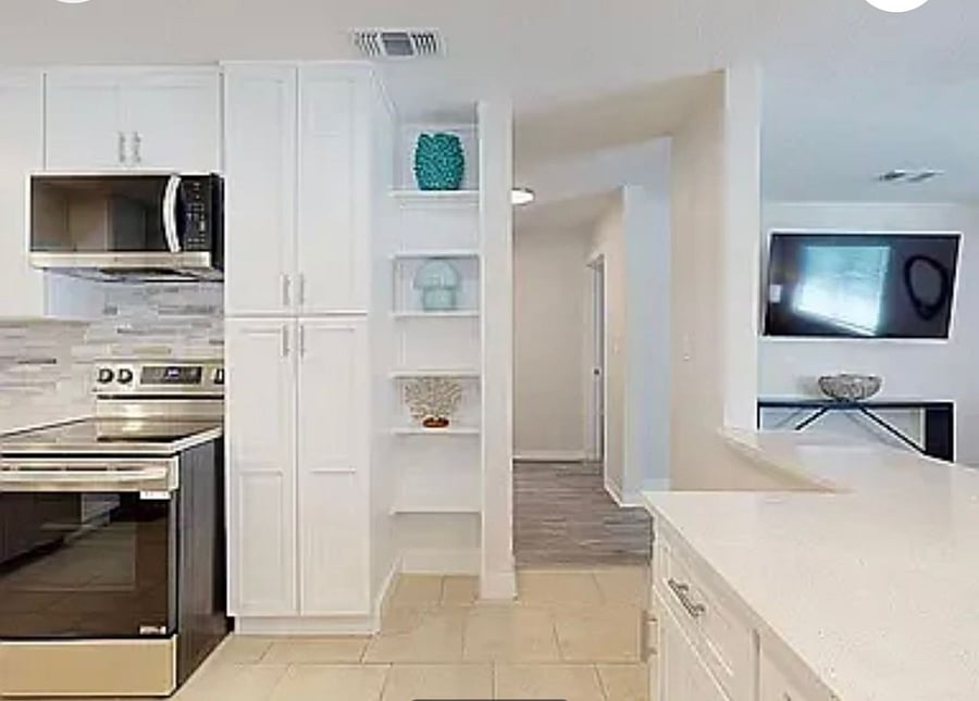 Spacious kitchen with ample cabinet space, stainless appliances, and pass-through to dining and living areas