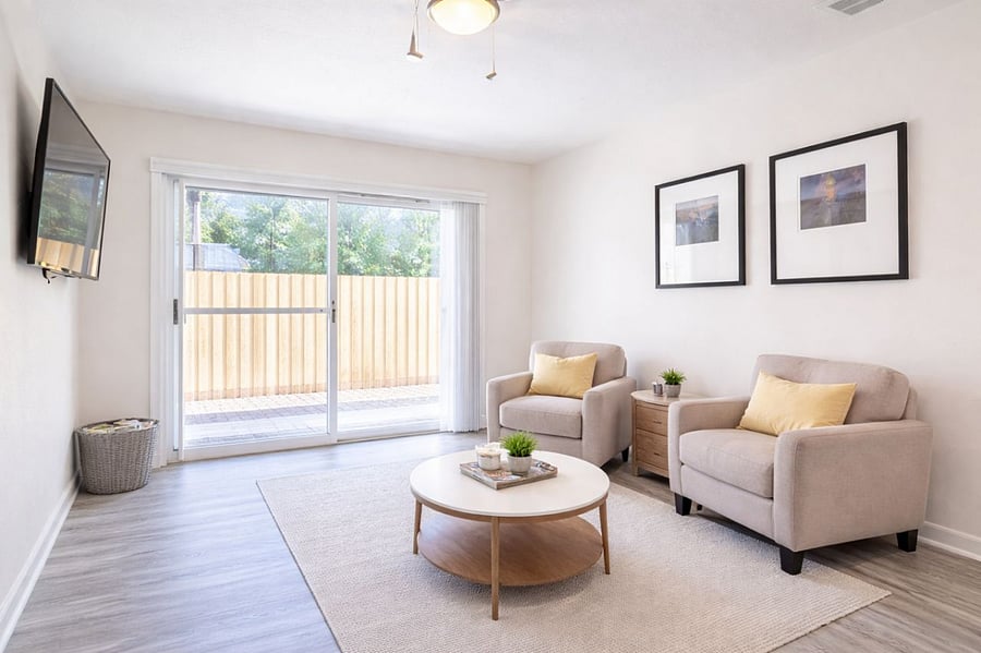Spacious common area flowing from living room to dining space with backyard access via sliding glass door