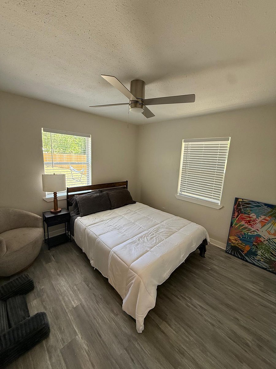 Cozy private room with hardwood-style floors, ceiling fan, and tasteful dcor