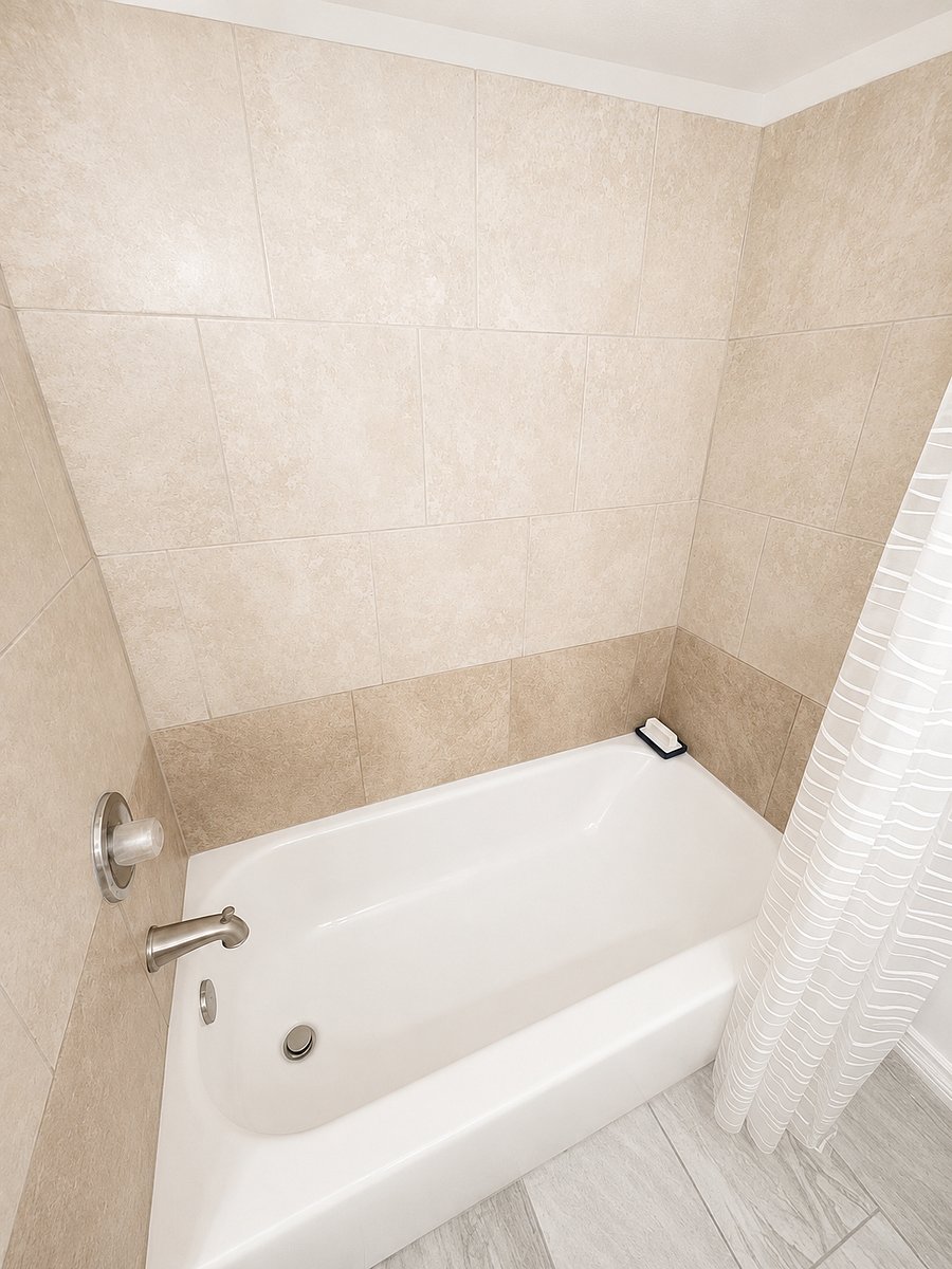 Modern shower and tub combination with sleek tile finishes.