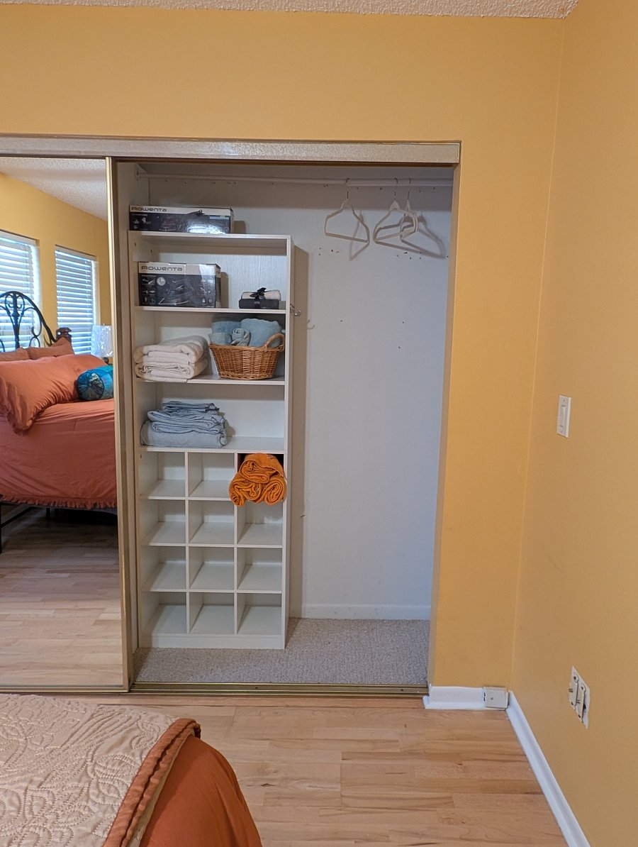 Shelf organizer in the closet. Ironing board and steamer also available